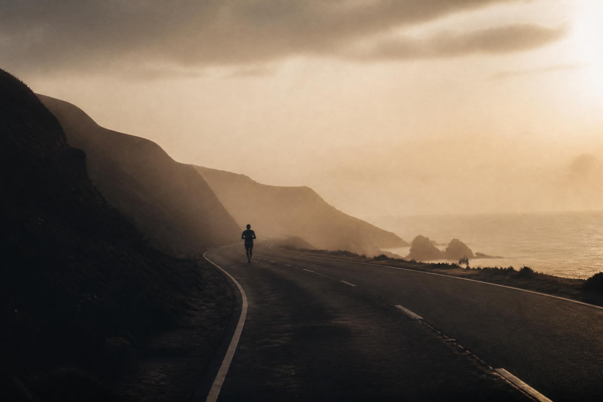 Corredor solitário ao amanhecer em uma estrada litorânea